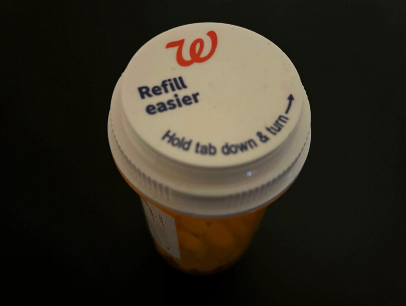A pill bottle from Walgreens on a table.