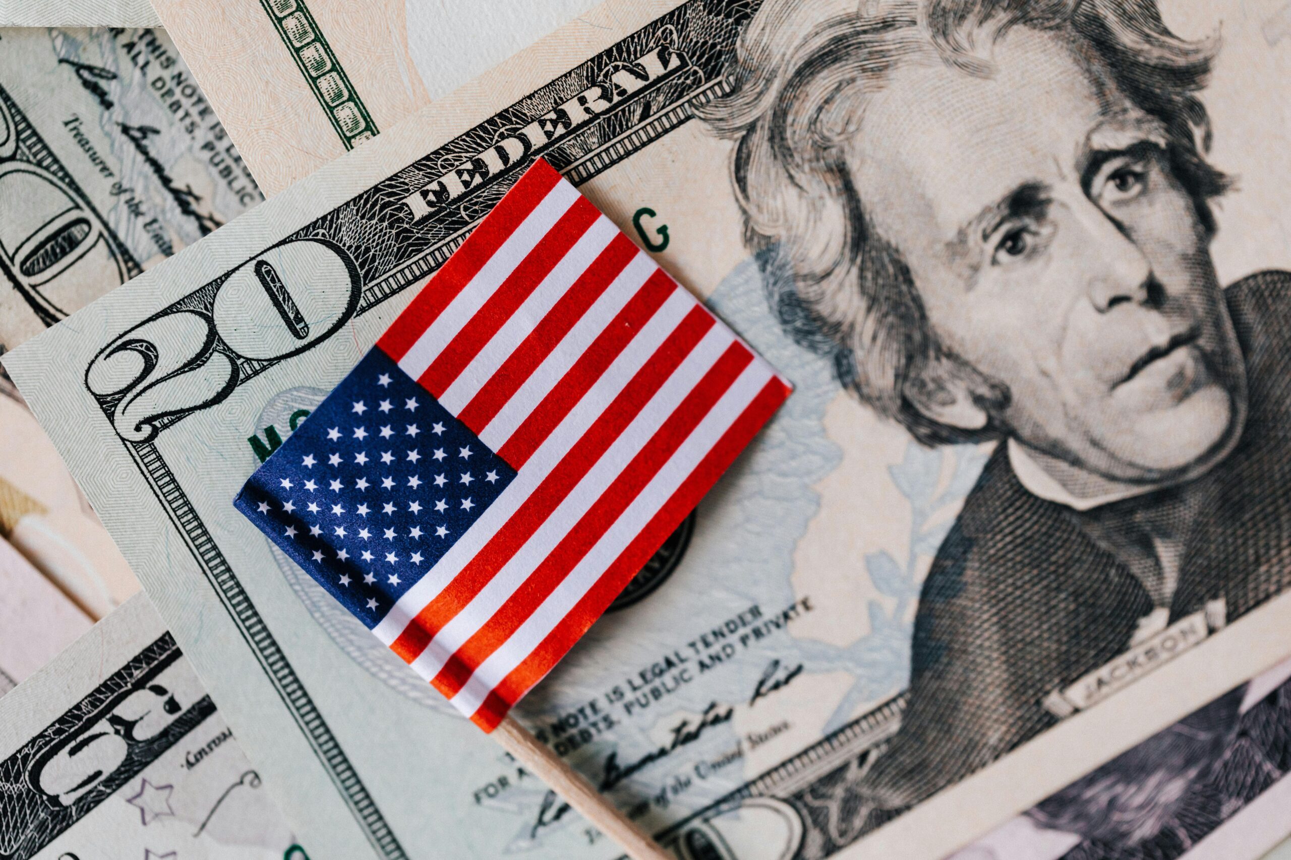 Twenty Dollar Bills and an American Flag on top of them.