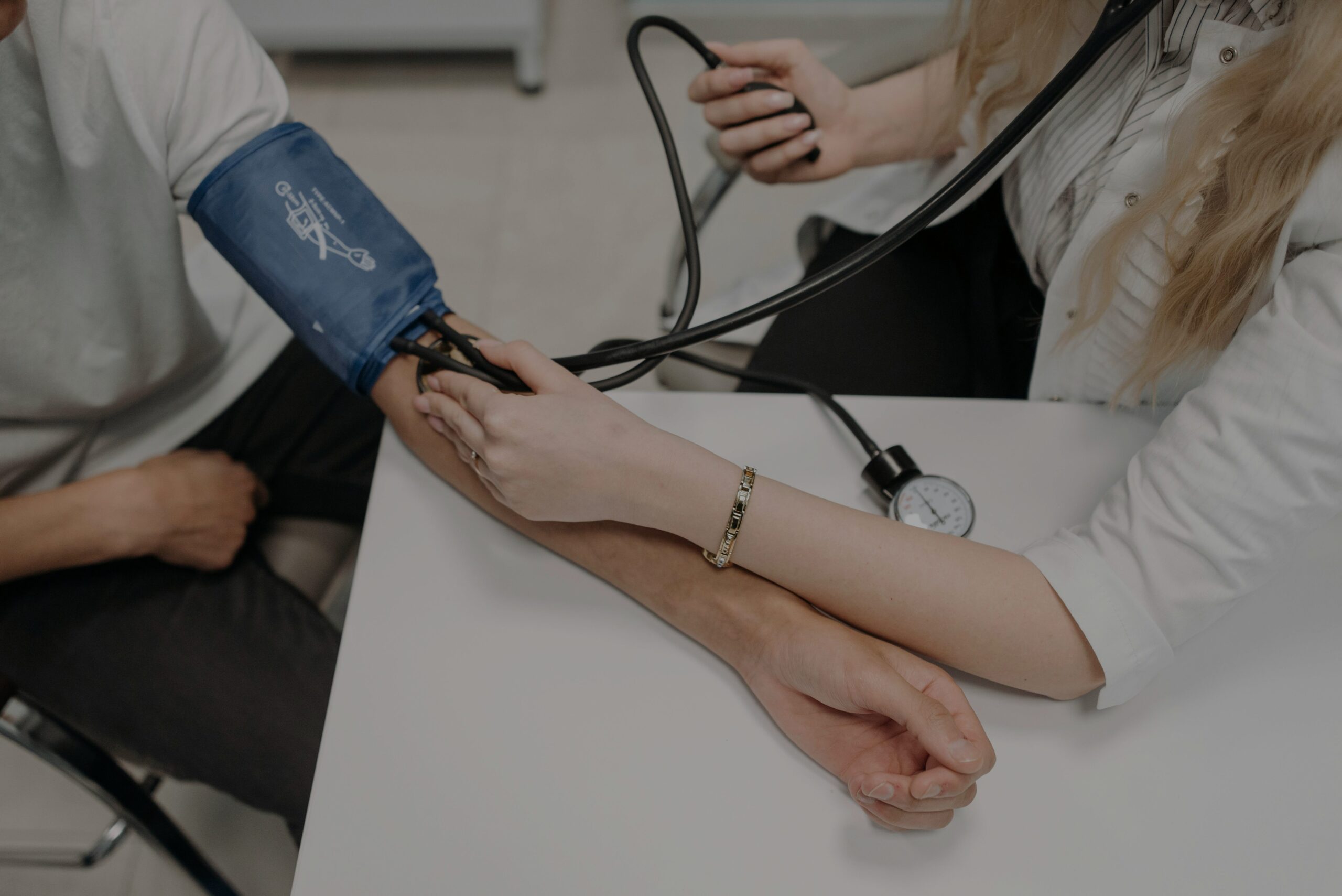 A doctor and patient measure blood pressure.